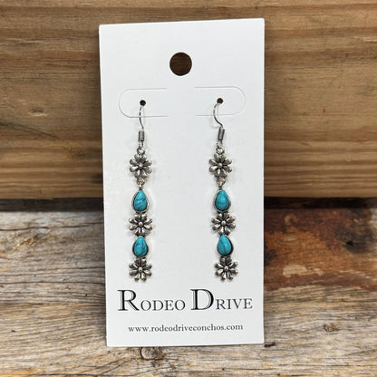 Silver-plated floral western earrings with turquoise teardrop accents and fish hook posts, perfect for cowgirl, western, and boho fashion.