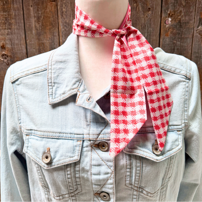 Mannequin wearing a denim jacket with a red and white checkered scarf against a wooden background